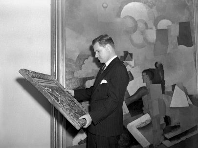 Nelson Rockefeller, prezident MoMA, si prohlíží jeden z obrazů, které budou zavěšeny v nové budově muzea, květen 1939. Repro: https://www.sothebys.com (Obr. 28)